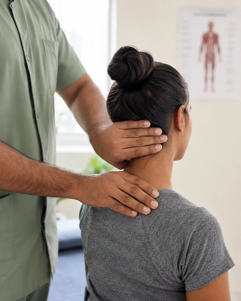 A physiotherapist treating a patient's neck and shoulder at Asha Physiotherapy Clinic
